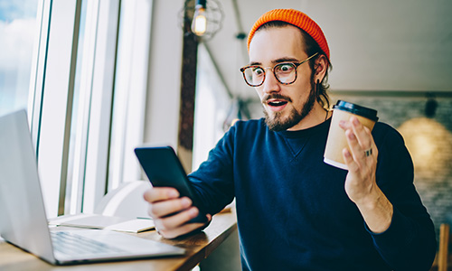 Hipster mit Kaffee, Laptop und Handy